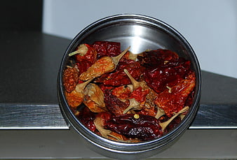 Dried red chili peppers in a stainless steel bowl