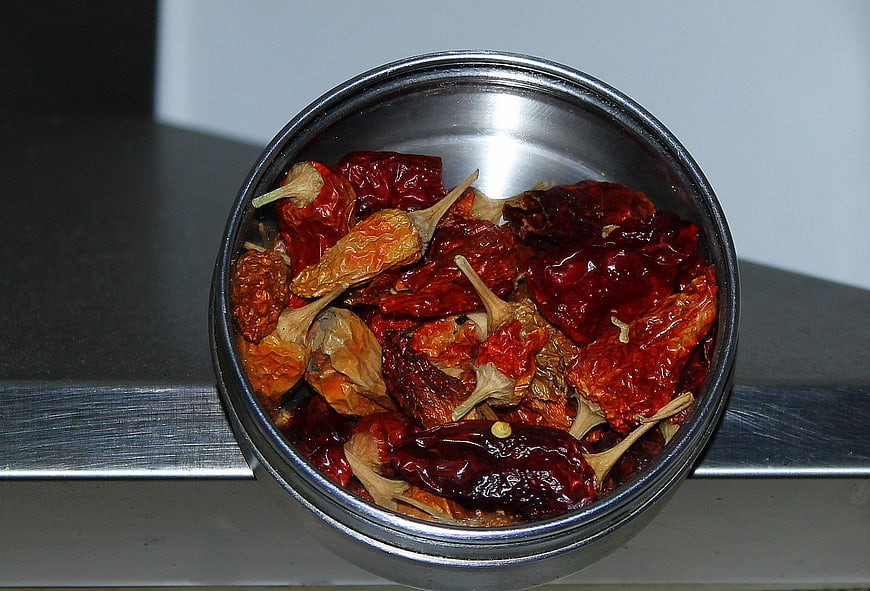 Dried red chili peppers in a stainless steel bowl