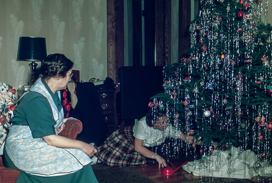 Vintage Christmas Scene with Woman and Child Decorating Tree