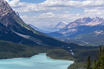 Turquoise glacial lake surrounded by pine forests and rugged mountains