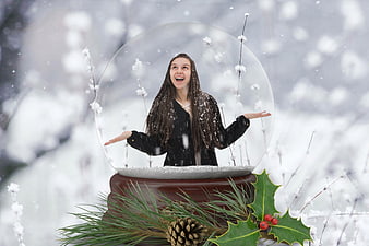 Woman inside giant snow globe in winter forest