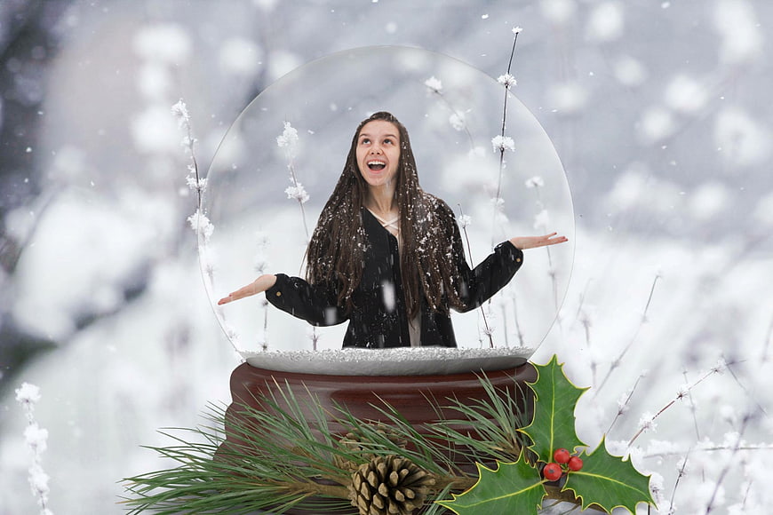 Woman inside giant snow globe in winter forest