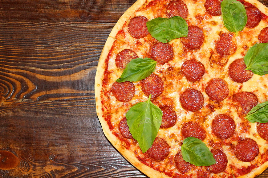Pepperoni Pizza With Fresh Basil On Rustic Wooden Table