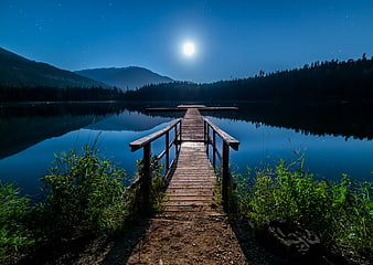 Wooden Dock on Lake Under Full Moon and Starry Night Sky