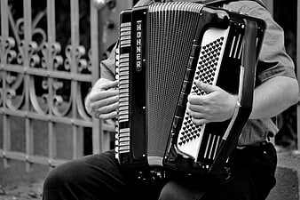 Close-up of musician playing Hohner accordion in black and white