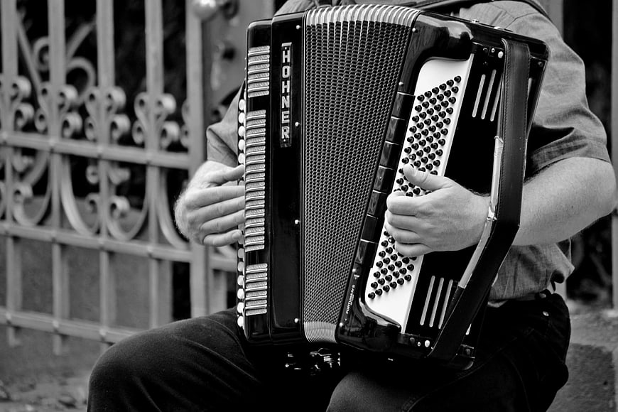 Close-up of musician playing Hohner accordion in black and white
