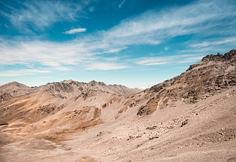 Arid Desert Mountain Landscape with Blue Sky and Clouds