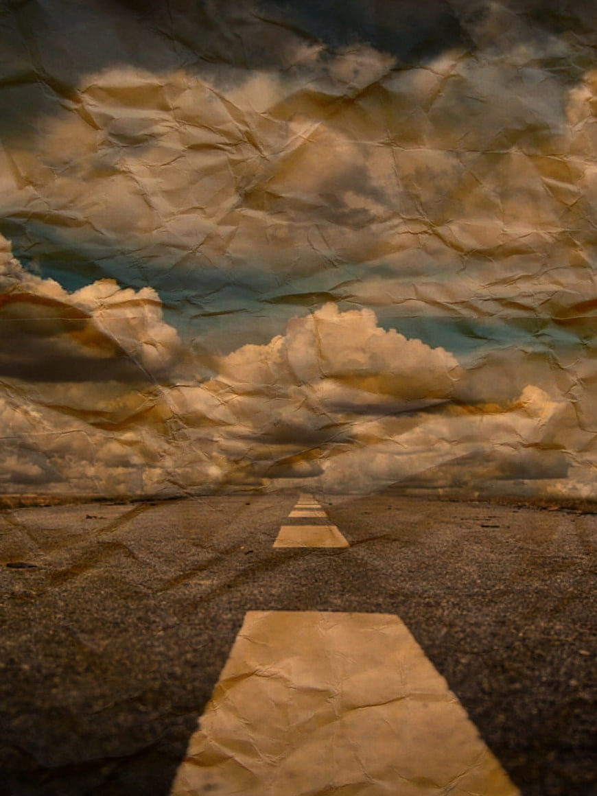 Crumpled paper texture overlay on road and clouds