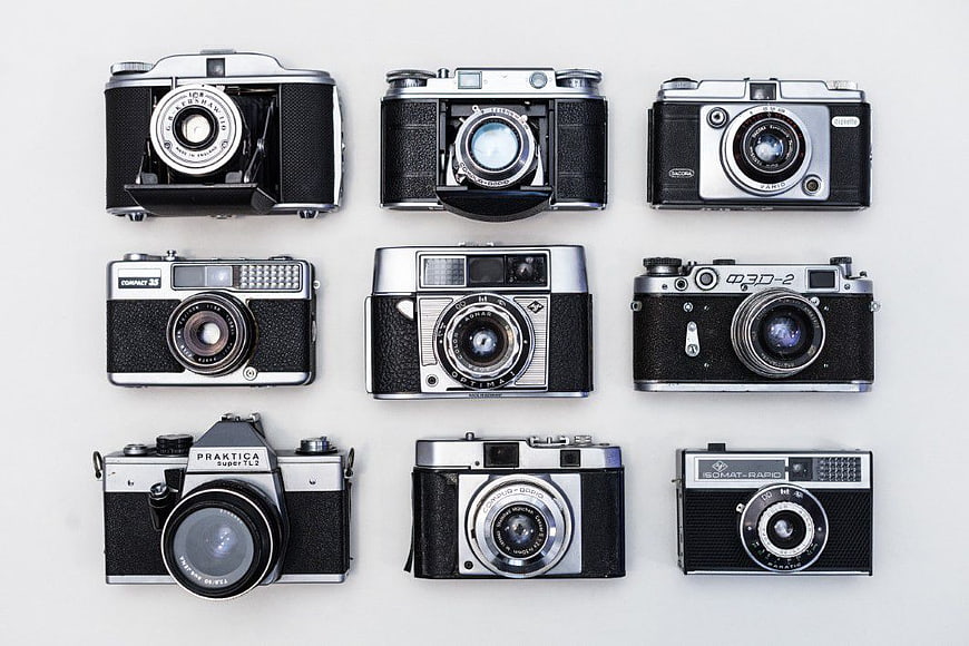 Grid of nine vintage film cameras on white background
