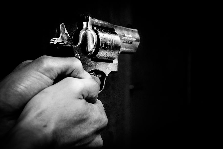 Hand Holding Revolver Pistol in Black and White