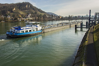 Blue cargo barge navigating river near lock gates