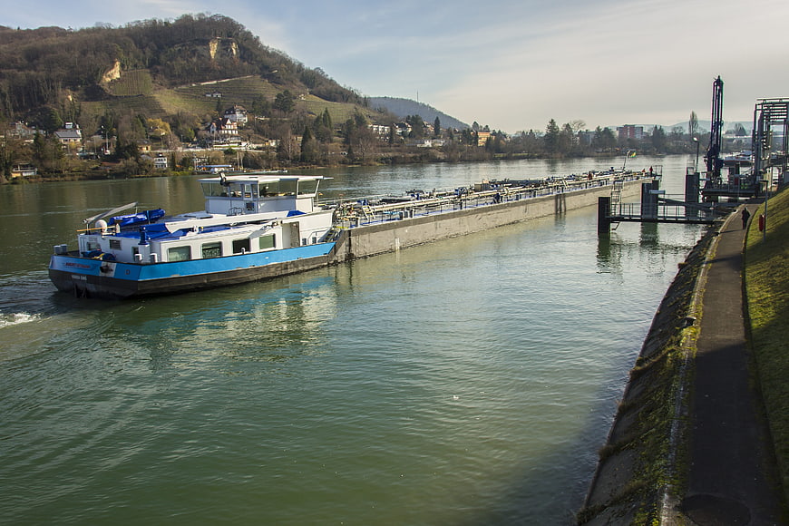Blue cargo barge navigating river near lock gates