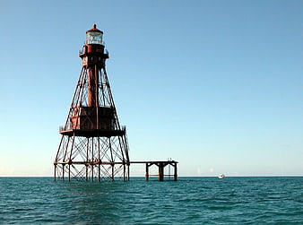 Red Steel Lighthouse Tower in Blue Ocean Water
