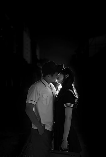 Black and white photo of a couple kissing in the dark