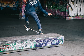 Skateboarder Grinding on Graffiti Box in Urban Setting