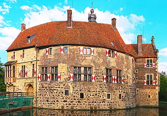 Historic Moated Castle with Red and White Flags
