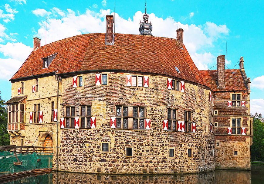 Historic Moated Castle with Red and White Flags