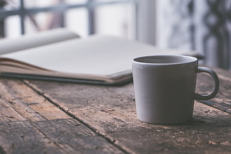 White Coffee Mug on Rustic Wooden Table with Open Book