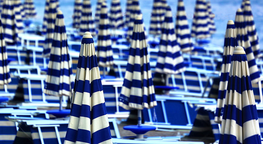 Blue and white striped beach umbrellas on a sunny day