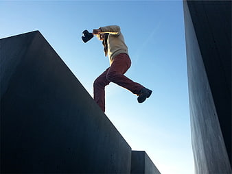 Man Jumping with Camera Between Concrete Slabs