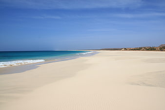 Empty Sandy Beach With Turquoise Water And Blue Sky