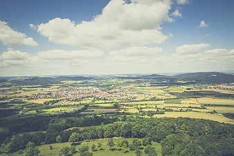 Aerial View of Green Valley with Town and Rolling Hills