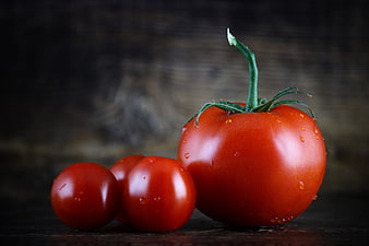 Fresh Red Tomatoes with Water Drops on Dark Wood