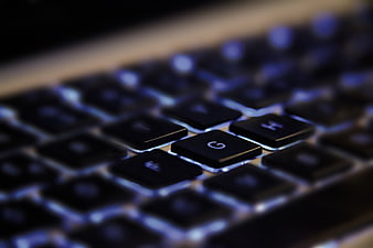 Close-up of illuminated laptop keyboard keys with blue backlight