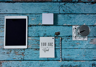 Flat lay workspace with tablet and motivational note on blue wood