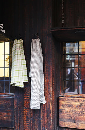 Textured towels hanging on rustic wooden wall