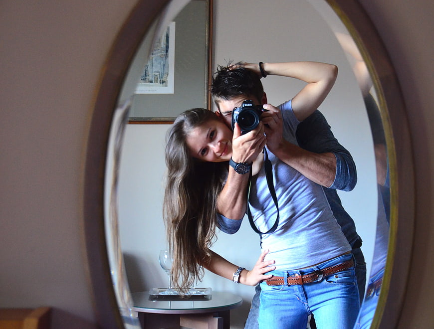 Couple taking mirror selfie with DSLR camera