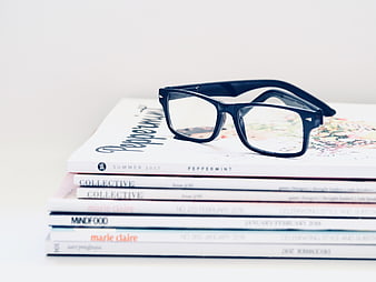 Blue Glasses on Stack of Magazines