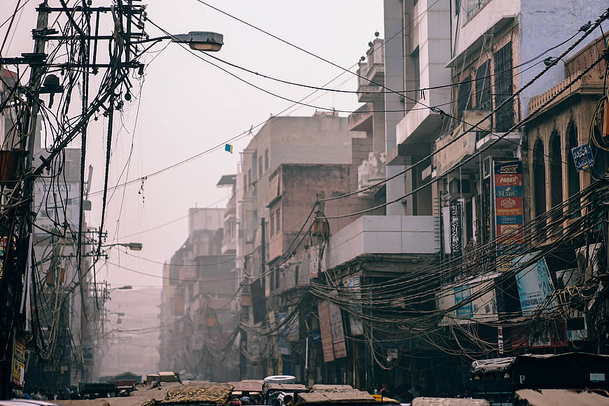 Chaotic urban street scene with tangled power lines in India