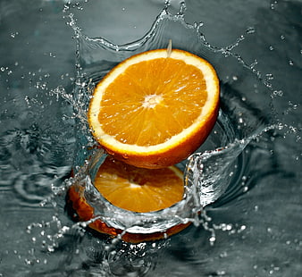 Fresh Orange Slice Splashing into Water