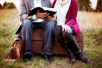 Couple Reading Bible on Outdoor Sofa in Field
