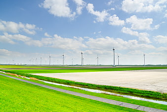 Wind turbines in green agricultural landscape with blue sky