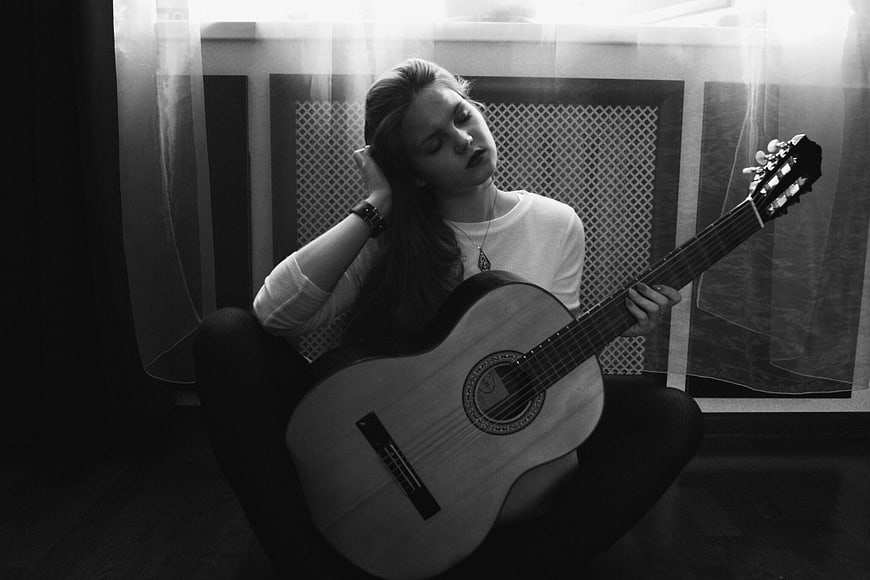 Young Woman Playing Acoustic Guitar in Black and White