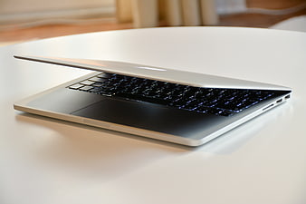 Silver laptop on white table with blurred background