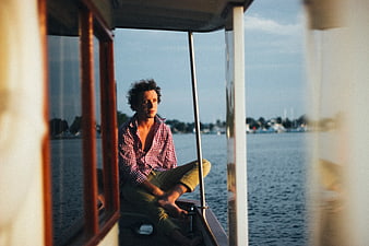Man sitting on boat edge looking out over water
