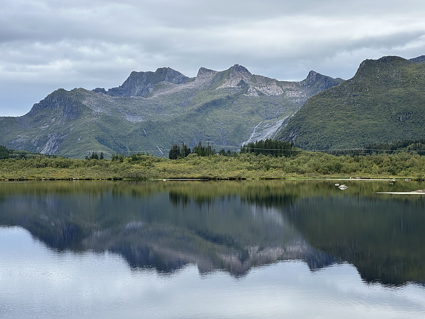 Serene Mountain Lake with Perfect Reflections and Green Hills