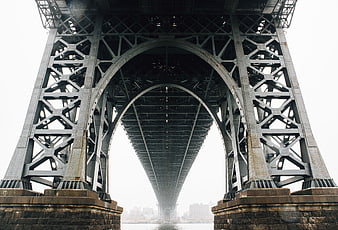 Low angle view of steel bridge arch structure over water