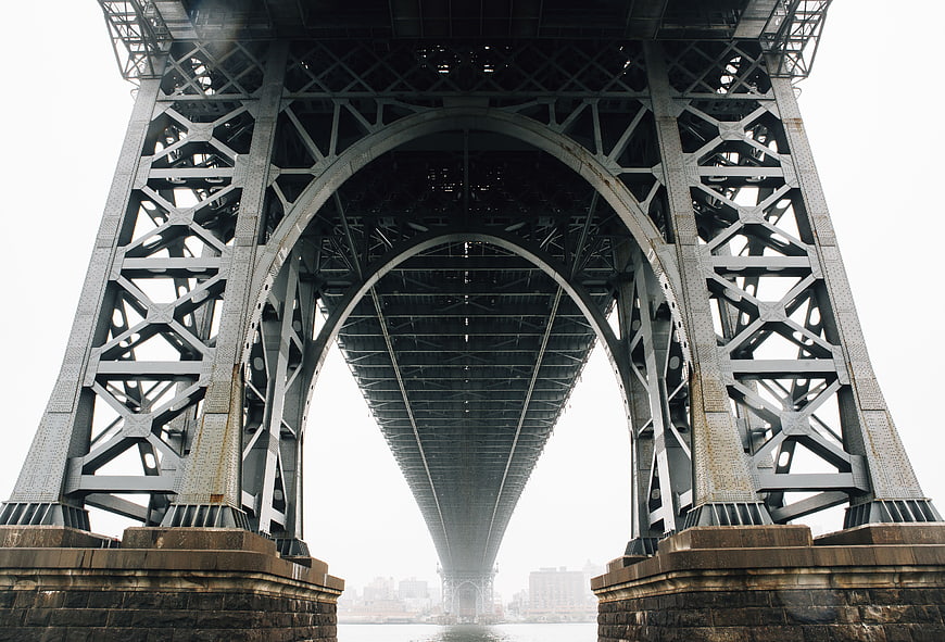 Low angle view of steel bridge arch structure over water