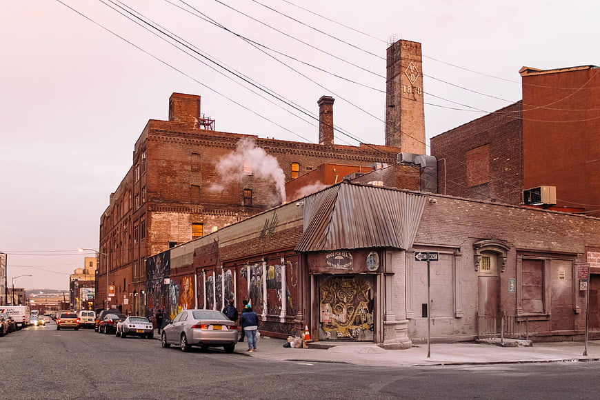 Urban street scene with brick buildings, graffiti, and steam