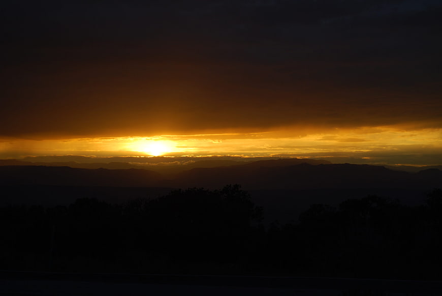 Dramatic Golden Sunset Over Silhouetted Mountain Ranges