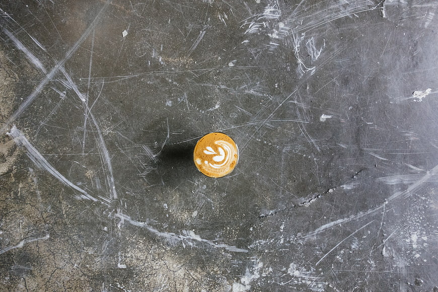 Top view of latte art coffee on scratched concrete background
