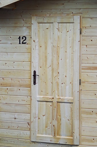 Light wooden door with number 12 on timber wall
