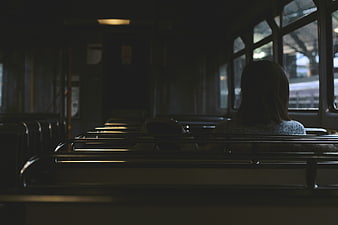 Lone Woman Sitting on Empty Train Car Interior