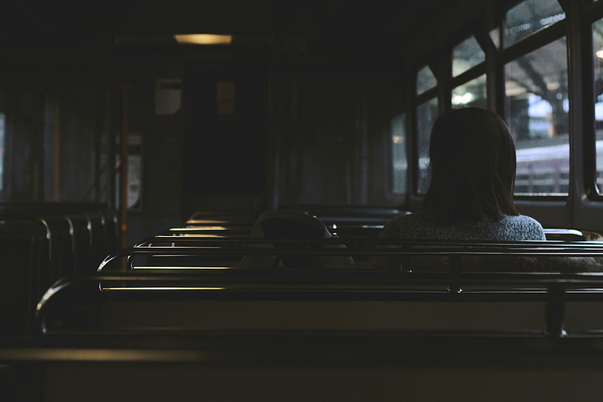 Lone Woman Sitting on Empty Train Car Interior