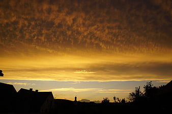 Dramatic Golden Sunset Sky Over Silhouetted Village