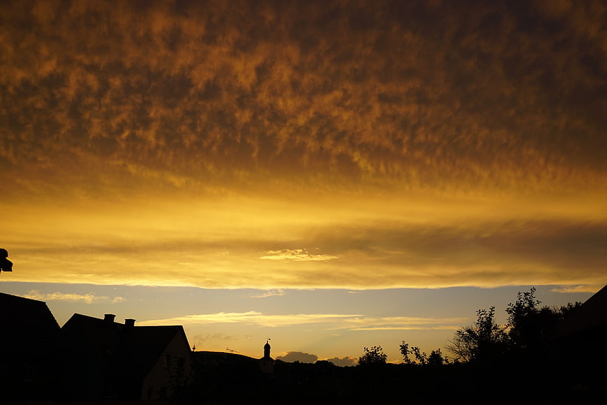 Dramatic Golden Sunset Sky Over Silhouetted Village